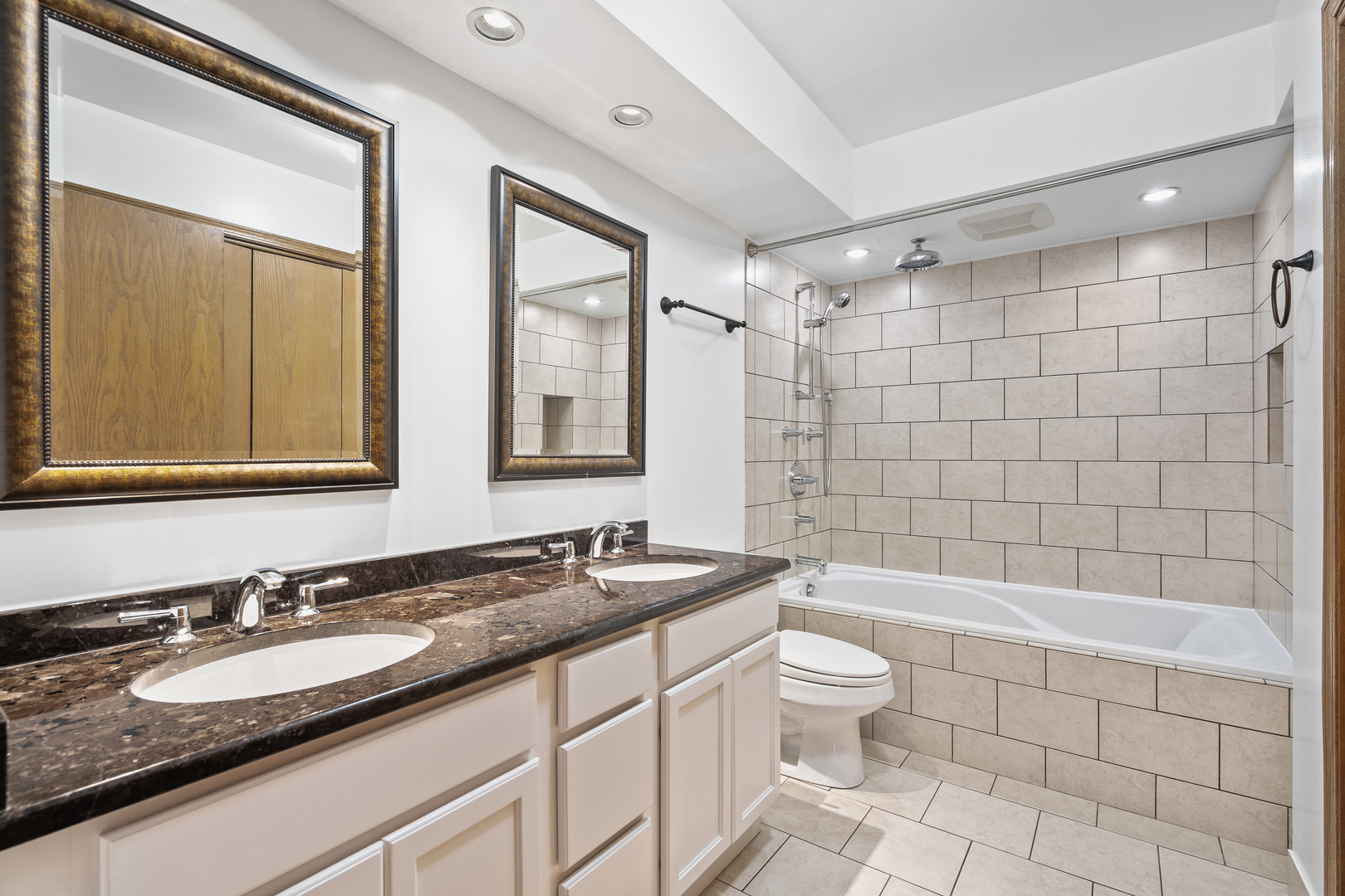 6400 West Berteau Avenue, Unit 405 Chicago, IL 60634 - Photo 15 of 22 a bathroom with a granite countertop sink a toilet a mirror a bathtub and shower