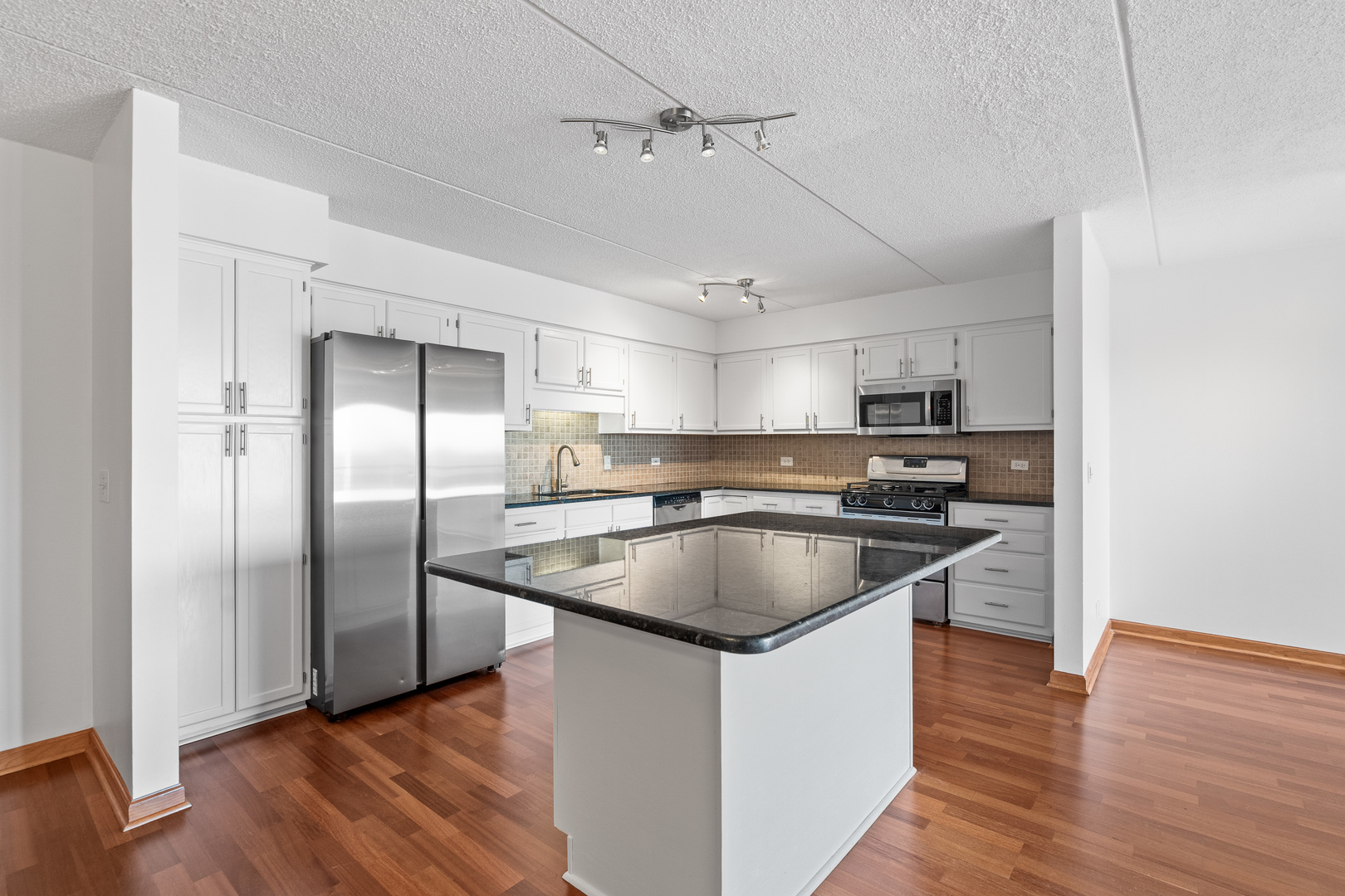 6400 West Berteau Avenue, Unit 405 Chicago, IL 60634 - Photo 5 of 22 a kitchen with stainless steel appliances granite countertop a sink a refrigerator and a stove top oven