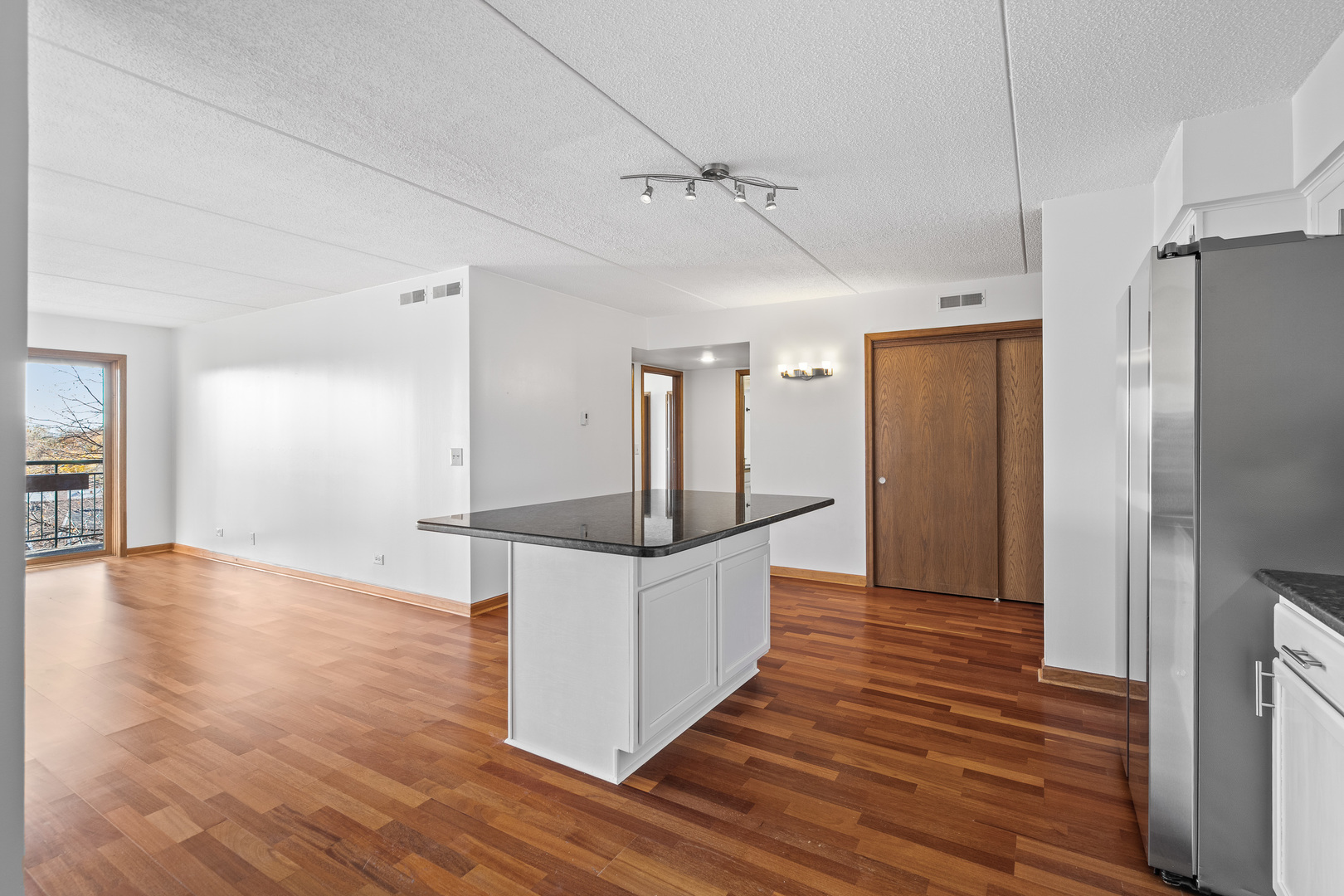 6400 West Berteau Avenue, Unit 405 Chicago, IL 60634 - Photo 7 of 22 a kitchen view with wooden floor and refrigerator