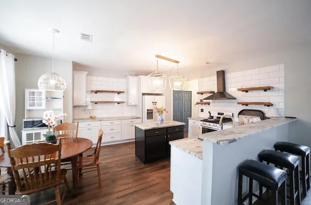 a living room with stainless steel appliances kitchen island granite countertop furniture and a large window