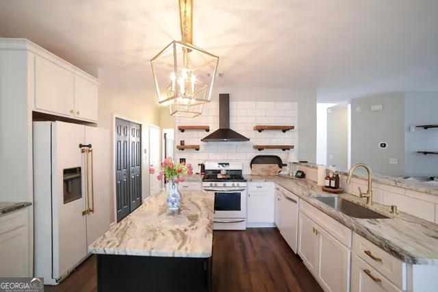 a kitchen with stainless steel appliances kitchen island granite countertop a stove a sink dishwasher a dining table and chairs with wooden floor