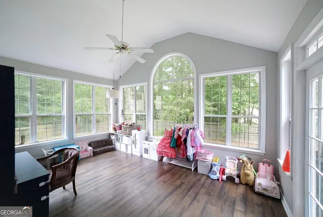 a living room with furniture a flat screen tv and a floor to ceiling window