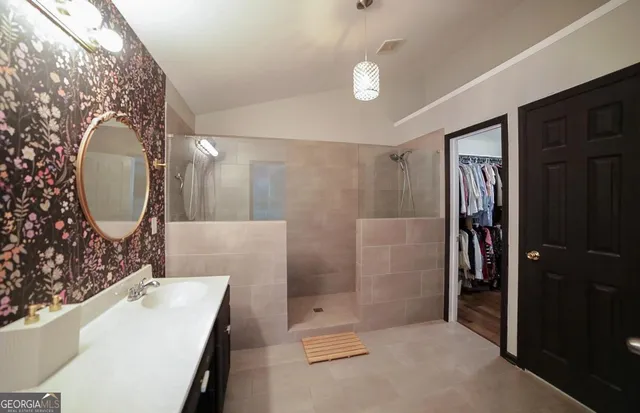 a bed sitting in a bedroom next to a window with a chandelier