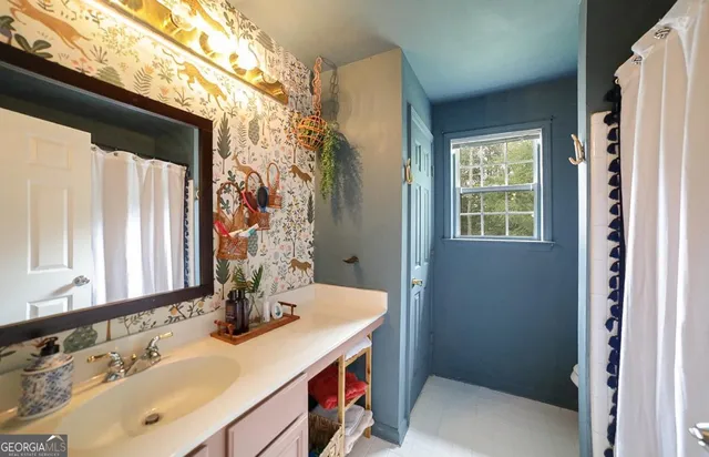 a bedroom with a bed next to a window with a chandelier