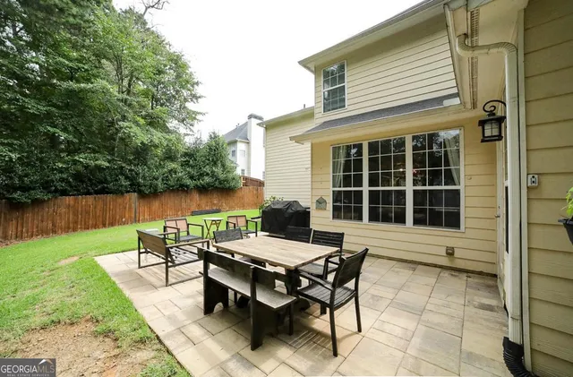 a view of a house with backyard and sitting area