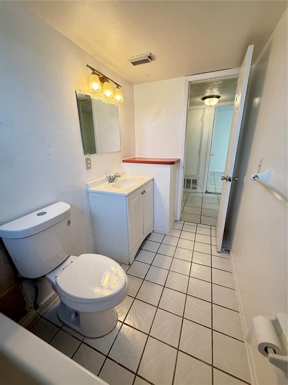 731 Michigan Court, Unit 1 St. Cloud, FL 34769 - Photo 11 of 18 a bathroom with a toilet a sink and a mirror