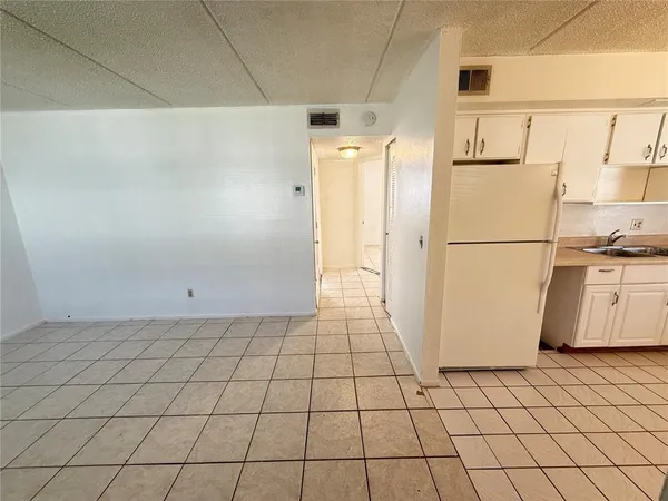a white refrigerator freezer and a stove sitting inside of a kitchen
