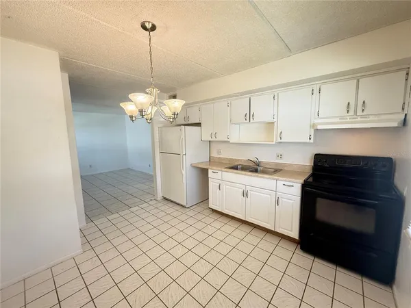 a kitchen with a stove a sink and a refrigerator