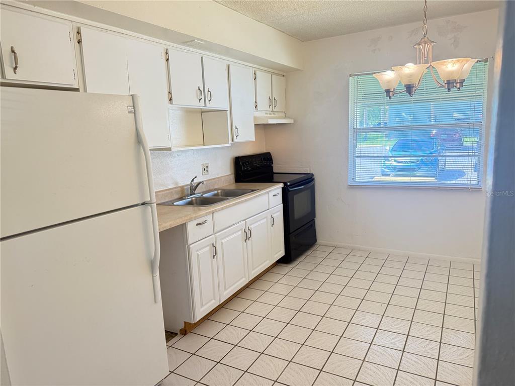 731 Michigan Court, Unit 1 St. Cloud, FL 34769 - Photo 6 of 18 a kitchen with stainless steel appliances a refrigerator sink and cabinets