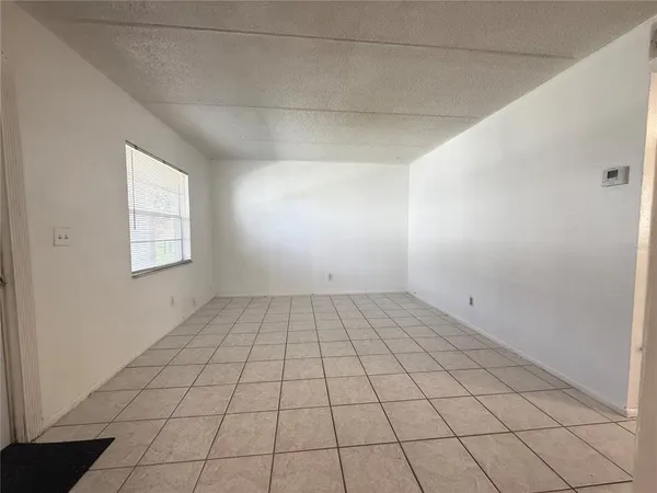 an empty room with white walls and tiles