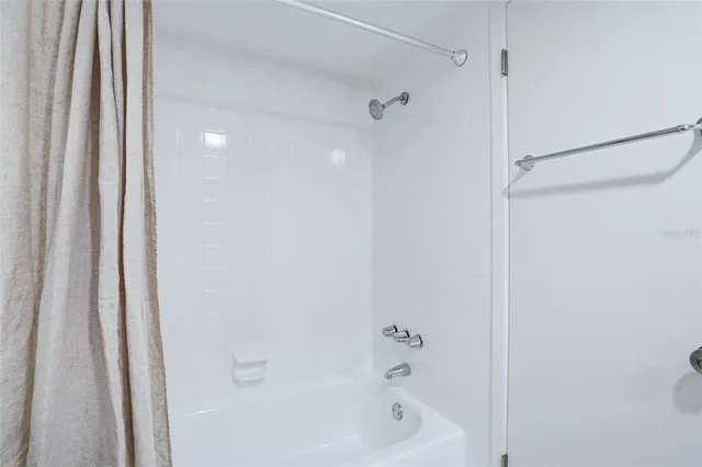 a white toilet sitting next to a shower