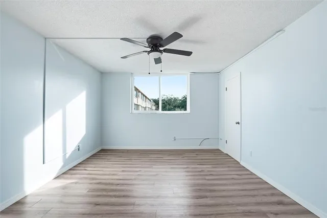 a view of empty room with wooden floor