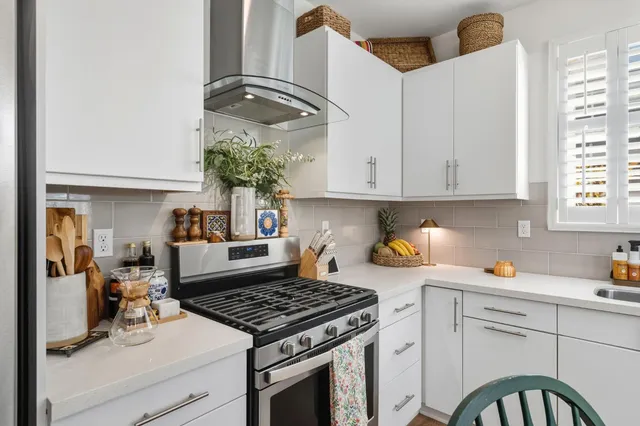 a kitchen with a stove and white cabinets