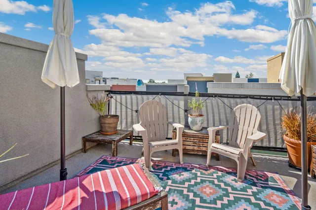 a balcony with couple of chairs and couch