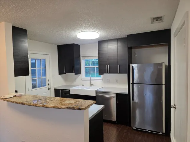 a kitchen with refrigerator and sink