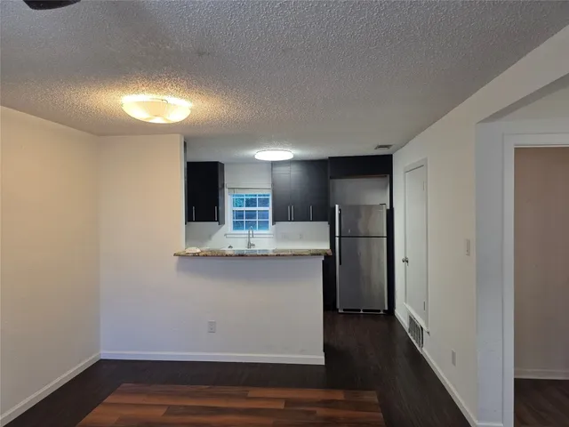 a view of kitchen with stainless steel appliances cabinets and wooden floor