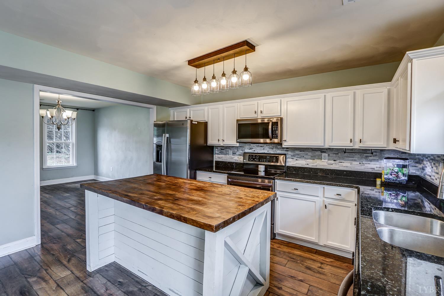 1057 Old Trail Road Forest, VA 24551 - Photo 10 of 49 a kitchen with stainless steel appliances granite countertop a sink dishwasher stove and oven with white cabinets