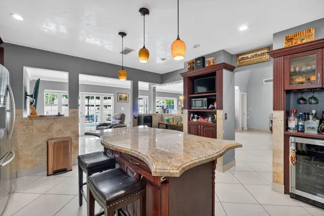 a kitchen with granite countertop a stove a kitchen island a sink and a refrigerator