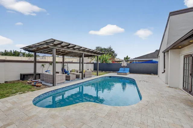 a view of a swimming pool with a patio and a yard