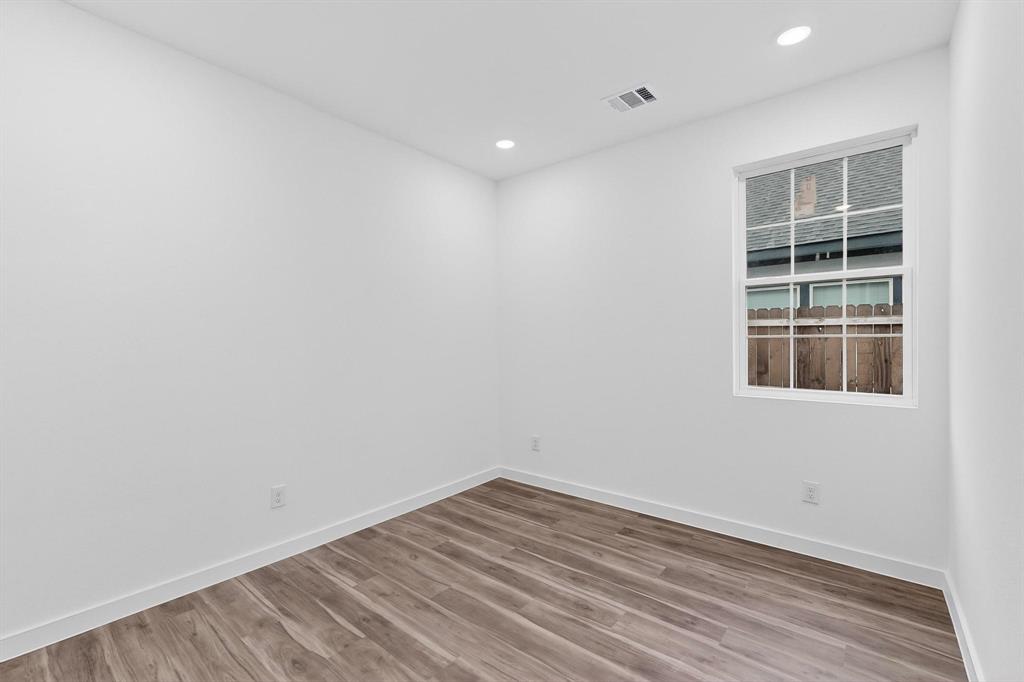 4606 Metropolitan Avenue Dallas, TX 75210 - Photo 14 of 21 an empty room with wooden floor and windows