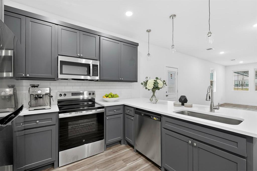 4606 Metropolitan Avenue Dallas, TX 75210 - Photo 6 of 21 a kitchen with kitchen island a sink stainless steel appliances and cabinets