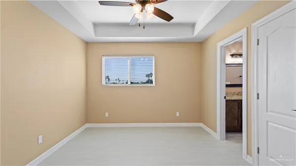 an empty room with a ceiling fan and carpet