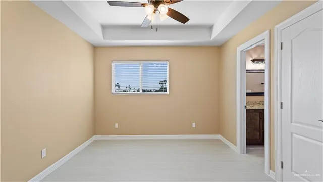 an empty room with a ceiling fan and carpet