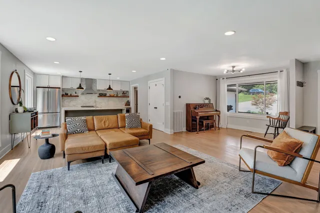 a living room with furniture and a dining table with rug