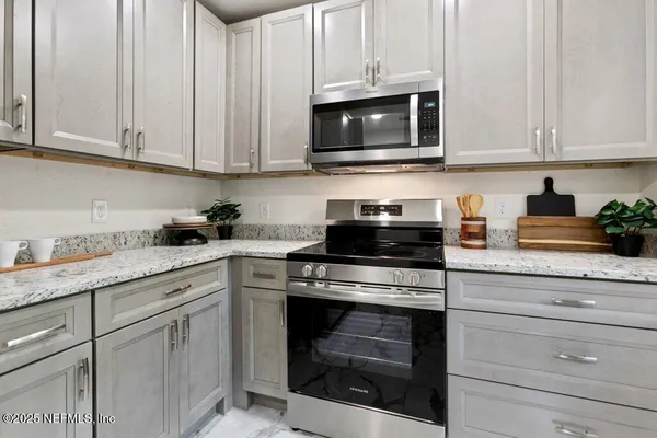 a kitchen with granite countertop white cabinets stainless steel appliances and sink