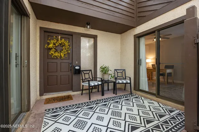 a view of a hallway with wooden floor and a rug
