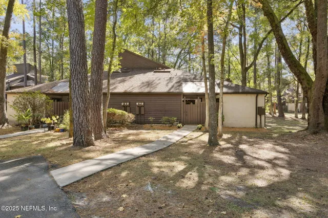a view of a house with backyard and trees
