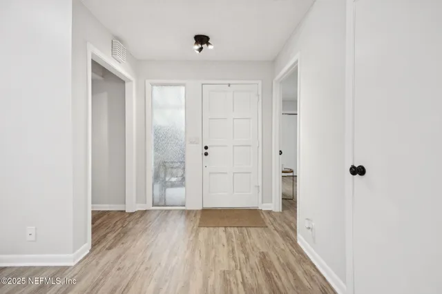 a view of a hallway with wooden floor