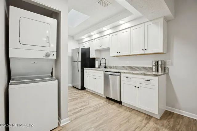 a kitchen with granite countertop white cabinets and white appliances
