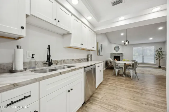 a kitchen with a sink cabinets and wooden floor