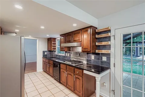 a kitchen with stainless steel appliances granite countertop a sink and a stove