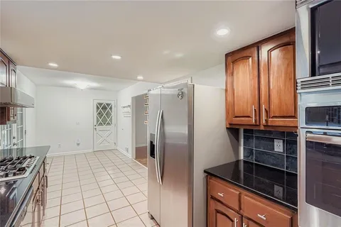 a kitchen with stainless steel appliances granite countertop a refrigerator and a stove top oven