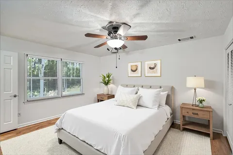 a bedroom with a bed chandelier and a window