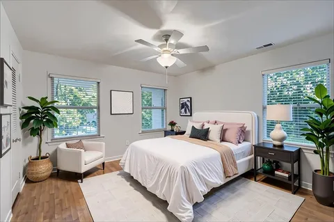 a bedroom with a large bed and a potted plant