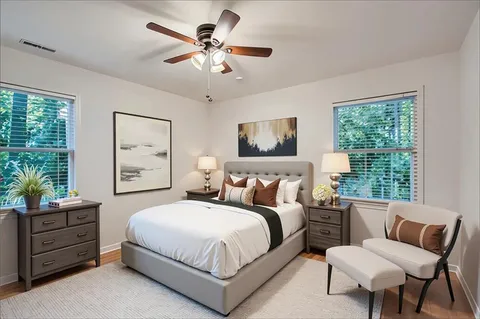 a bedroom with a bed a chandelier and a couch