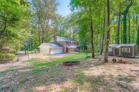 a view of a house with backyard and trees