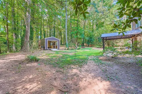 a view of a house with backyard and trees