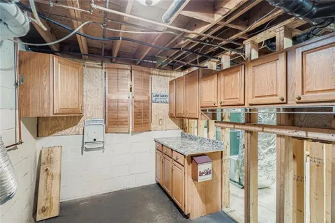 a utility room with stainless steel appliances granite countertop a stove and a sink