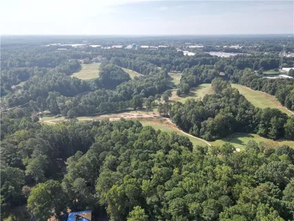 an aerial view of residential houses with outdoor space and trees