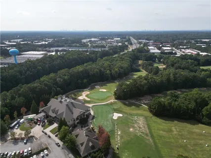 an aerial view of residential houses with outdoor space and trees
