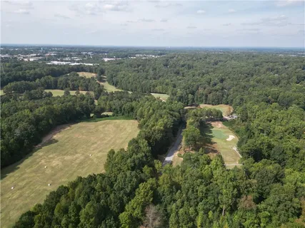 an aerial view of residential houses with outdoor space and trees