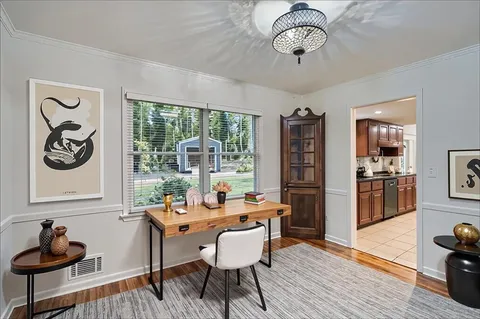 a dining room with furniture a window and wooden floor
