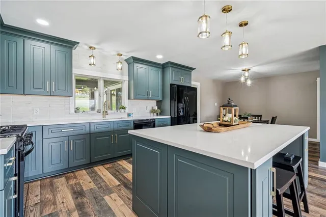 a kitchen with a sink a stove and chairs