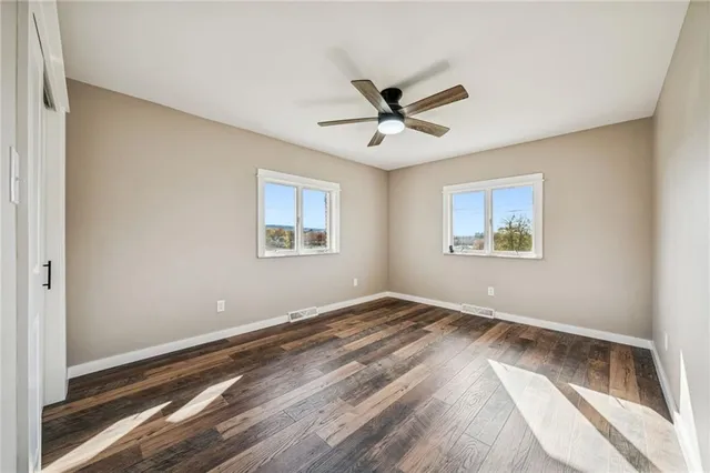 a view of empty room with wooden floor