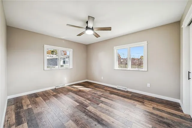 a view of empty room with wooden floor