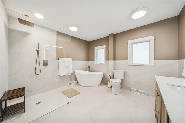 a bathroom with a tub sink and mirror